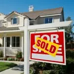 Sold Home For Sale Sign in Front of Beautiful New House.